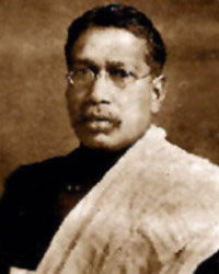 Small sepia-toned head-and-shoulders portrait of Bipin Chandra Pal wearing spectacles and a light shawl over a dark garment.
